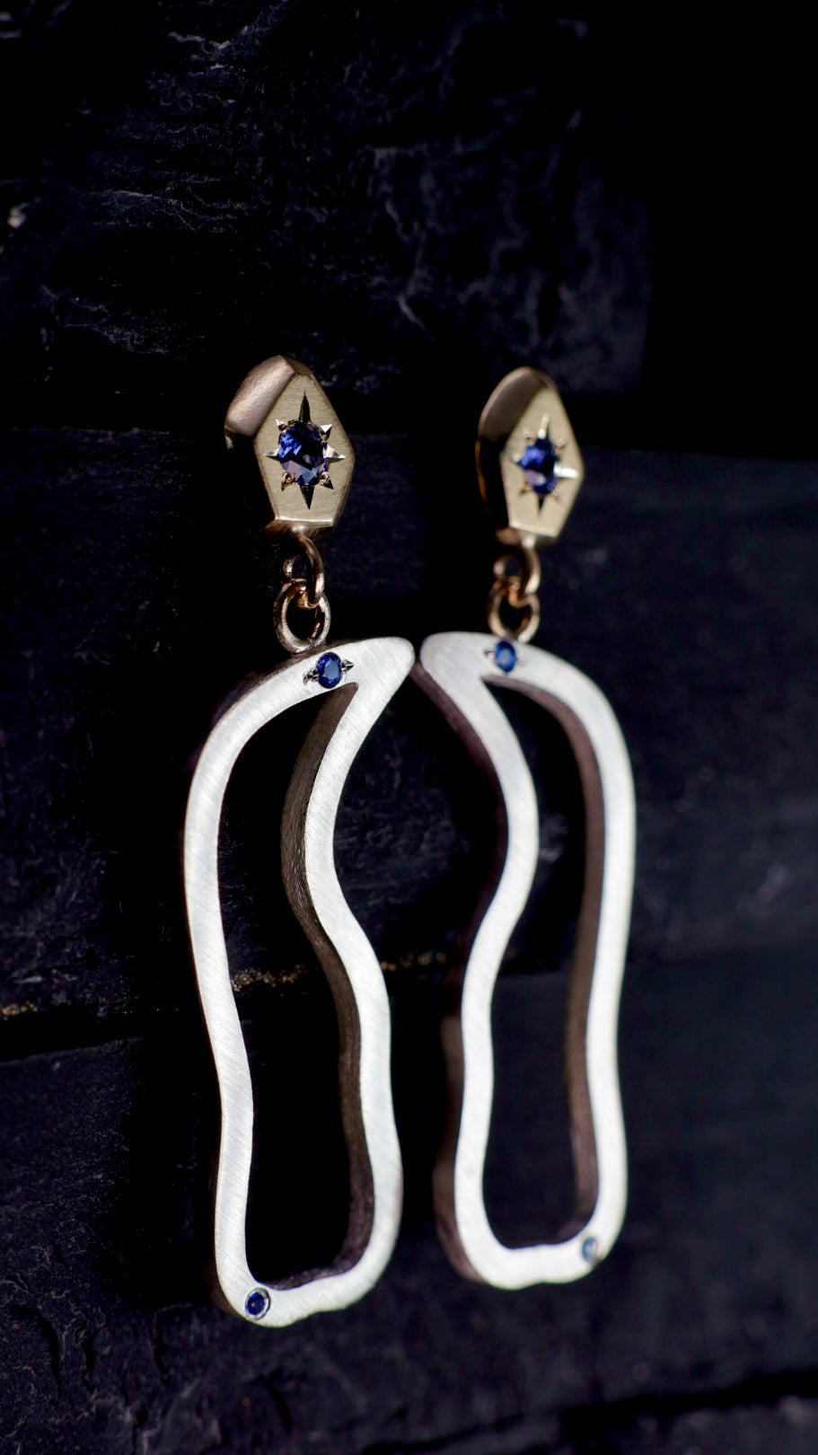 16. Robyn Clarke, Birrarung Cormorant Earrings, 9ct yellow gold carved rock- shaped studs set with bright blue sapphires, with sterling silver drops set with small bright blue sapphires