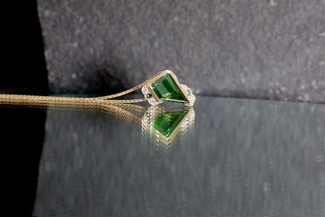 18. Robyn Clarke, Mystic Weight Pendant 1, 9ct yellow gold with a 1.31ct trapezoid green tourmaline, 2 x 1.5mm teal sapphires, 4 x 1.0/1.3mm EF/SI diamonds, on 9ct yellow gold 45cm chain