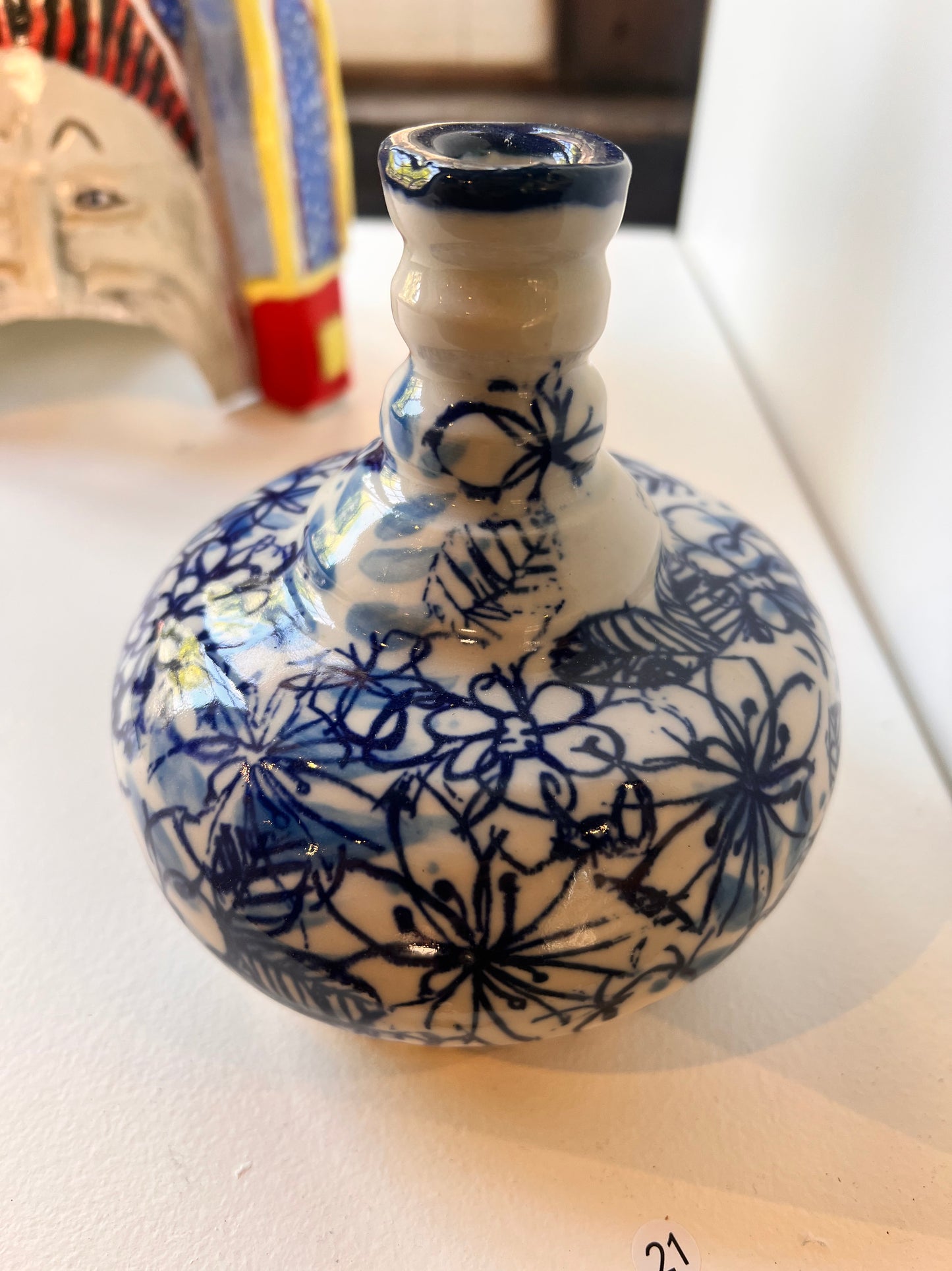 21. Lilli Wilson, 2025, Wednesday 3B, "Blue", - a porcelain like white vase with blue floral design through the vase.