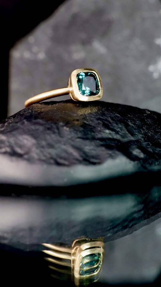 5. Robyn Clarke, Isla del Sol Ring 1, 18ct yellow gold, 1.64 carat cushion cut teal Queensland sapphire,  2 x EF/SI diamonds, size M