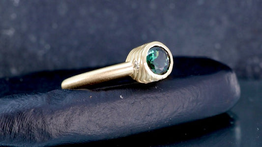 10. Robyn Clarke, Lagunas Ring 3, Laguna Verde (contour line precursor) 9ct yellow gold, 0.84 carat bright green Queensland sapphire, 4 x 1.75mm EF/SI diamonds, size M