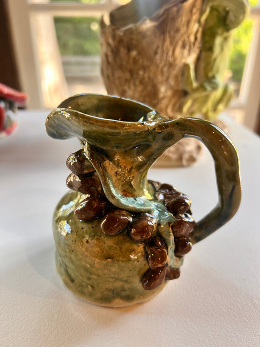 31. Sophia Di Luca, 2025, Monday 1A, "Heart of Sicily". An Olive oil jug with 3D shaped brown kalamata olives. Ceramic, Stoneware
